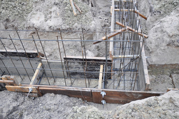 Building T-Shaped Concrete House Foundation with Slabs and iron Bars.
