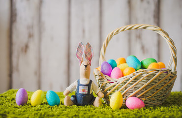 hare sitting on the grass with Easter eggs