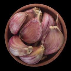 garlic in wooden cup isolated on black background.  top view