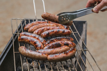 Grilling sausages on barbecue grill outdoor
