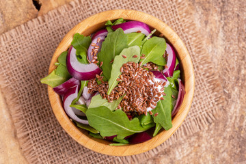 Healthy salad with fresh spinach, red onion and flax seeds