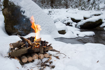 Campfire on snow in the winter forest