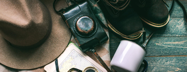 vintage camera hat and rustic-style plaid on a dark background vintage stuff and old compass things to travel in the mountains
