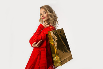beautiful young girl in a red dress with packages in their hands on a white background