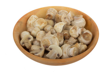 heap of champignons in wooden plate isolated on white background
