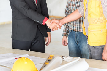 Closed up of businessman shake hands with engineering in construction renovate building site.