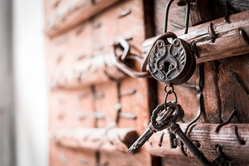 An antique and weathered vintage key.Old and rusty padlock on a vintage wooden door.