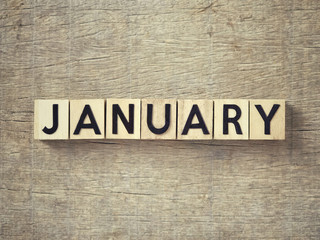 Motivational and inspirational word - ‘JANUARY’written on wooden blocks and arranged on a wooden table.