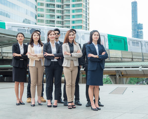 Fototapeta premium Group of professional multiracial business people standing in row outdoor office, background is modern building in modern city