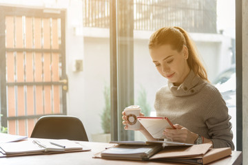 Happy relaxed young caucasian woman sitting in living room with a laptop her  smile, relax after a long work at laptop. Business, freelance start up ,education and lifestyle concept