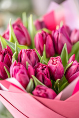 Obraz premium Bouquets of violet tulips. Spring flowers from Dutch gardener. Concept of a florist in a flower shop. Wallpaper.