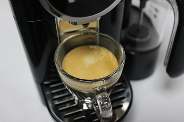 Coffee espresso pouring out of coffee machine