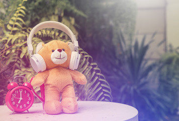 Brown bear with headphone and red alarm clock, Relax morning time decoration concept. copy space ,vintage toned