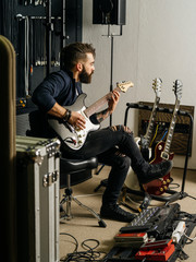 Playing his electric guitar in the recording studio