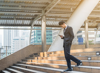 Young business people using cell phone walking ,standing separate discussion meeting on path outside office before starting work in their office.Outdoor city Business communication lifestyle concept.