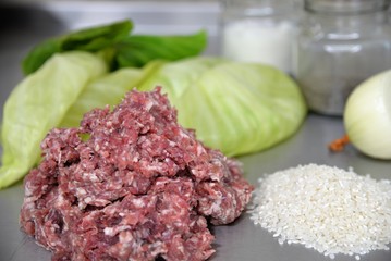 Chopped meat with rice on the background of onions, cabbage and jars of spices