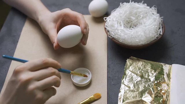 Girl decorates gold eggs for Easter