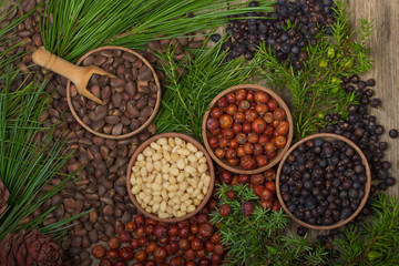 cedar nuts and juniper berries on wooden background