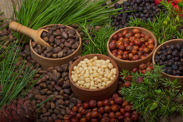cedar nuts and juniper berries on wooden background