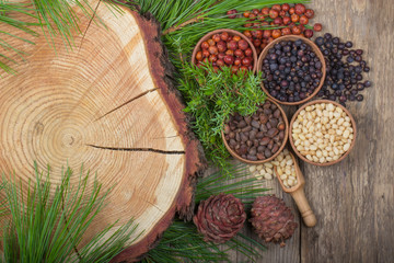 cedar nuts and juniper berries on wooden background