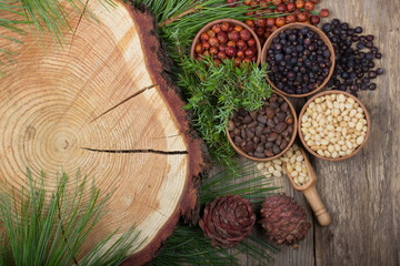 cedar nuts and juniper berries on wooden background