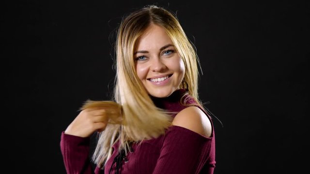 Pretty blond woman smiling and acting playful.