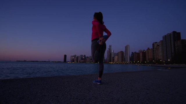Hispanic Caucasian female silhouette stretching at sunrise after cardio workout