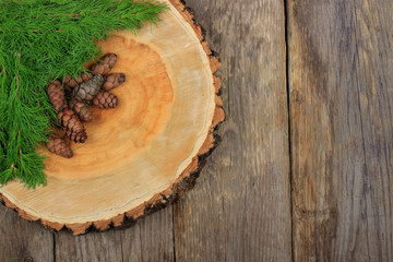 heap of cones of larch with branches on wooden background
