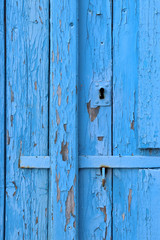 Blue peeling paint on an old wooden barn wall.