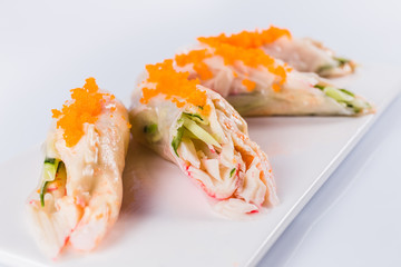 Rolls of rice paper with vegetables and seafood on white background isolated. Traditional Japanese cuisine