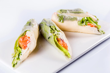 Rolls of rice paper with vegetables and seafood on white background isolated. Traditional Japanese cuisine