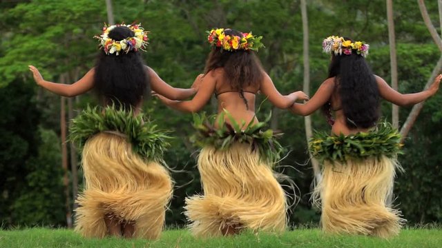 Group of beautiful young synchronized Polynesian female dancers entertaining in traditional costume barefoot outdoor French Polynesia South Pacific