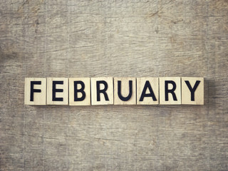 Obraz premium Motivational and inspirational word - ‘FEBRUARY’ written on wooden blocks and arranged on a wooden table.