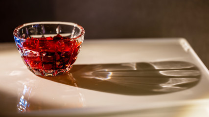 The saucer with raspberry jam with gray and brown background. This picture made by middle format camera.