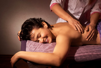 Closeup of massage on a pink background. Back massage. Spa salon. Spa body massage treatment.