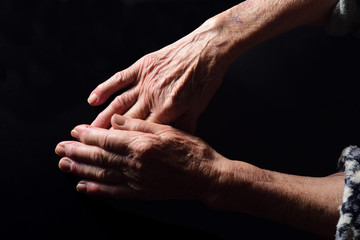 hands of senior woman on black