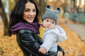 Fototapeta premium young beautiful Caucasian girl mom holding her little boy baby son