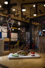 Pork Steak Sandwich on a wooden board with fresh vegetables