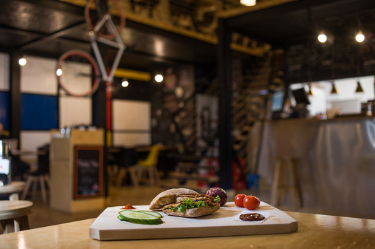Pork Steak Sandwich on a wooden board with fresh vegetables