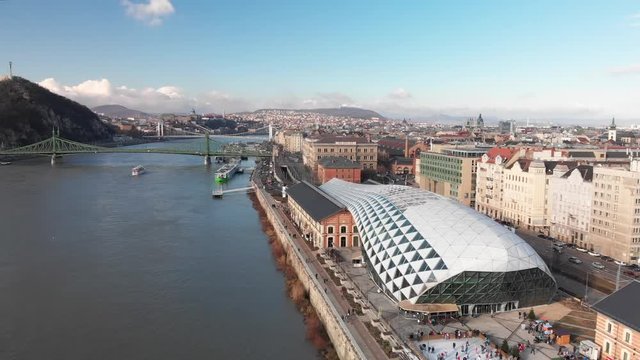 Aerial shot panning over the Balna Cultural Centre and across The Danube, a beautiful river running through Budapest, Hungary.