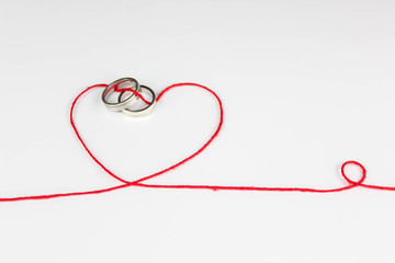 wedding ring joined with heart of thread