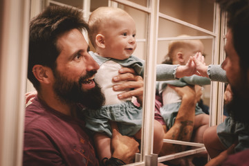 Baby laughing in front of a mirror