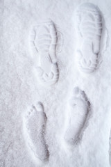 Hardy person strengthens his health, leaving traces of his bare feet in the snow in winter in cold weather, and then he put on his boots and left, leaving an imprint of the soles of his shoes. 