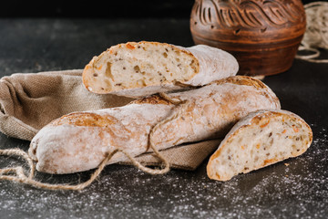 Fresh baked baguetes on the black wooden background