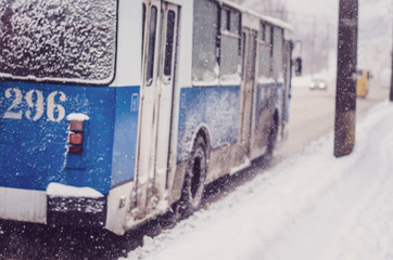 23.01.2019 Vinnitsa,Ukraine: Public transport moves along a snowy and dirty road in the city during snowfall, a blue trolley bus