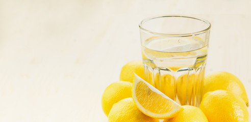 Glass of water with piece of lemon or fresh hand made lemonade