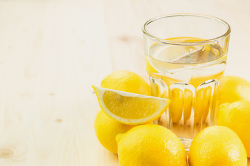 Glass of water with piece of lemon or fresh hand made lemonade
