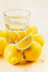 Glass of water with piece of lemon or fresh hand made lemonade