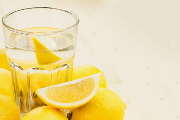 Glass of water with piece of lemon or fresh hand made lemonade
