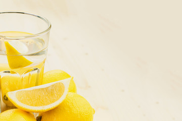 Glass of water with piece of lemon or fresh hand made lemonade